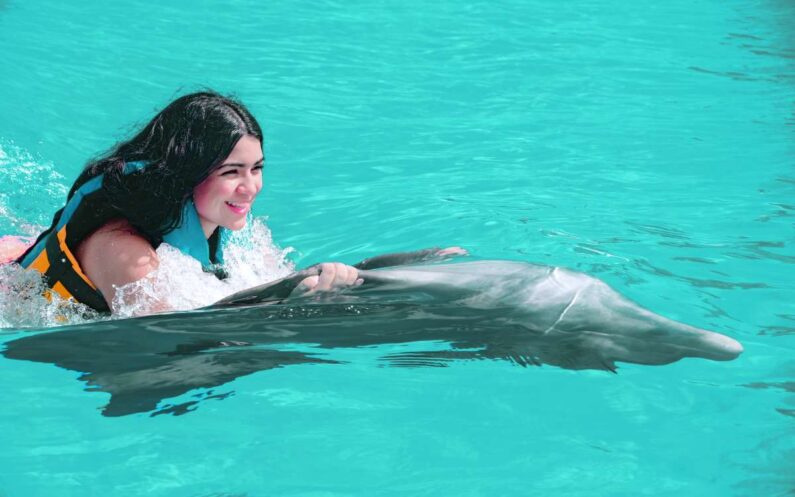 mujer hace nado con delfines en punta cana